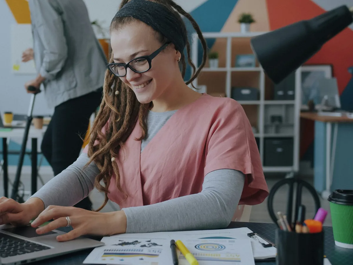 Designer smiling while building a website on her laptop